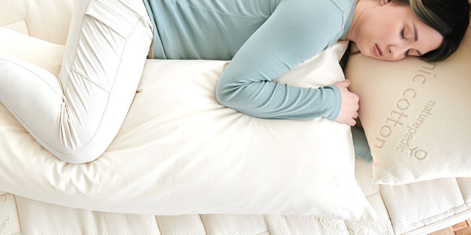 woman sleeping on her side with Naturepedic body pillow
