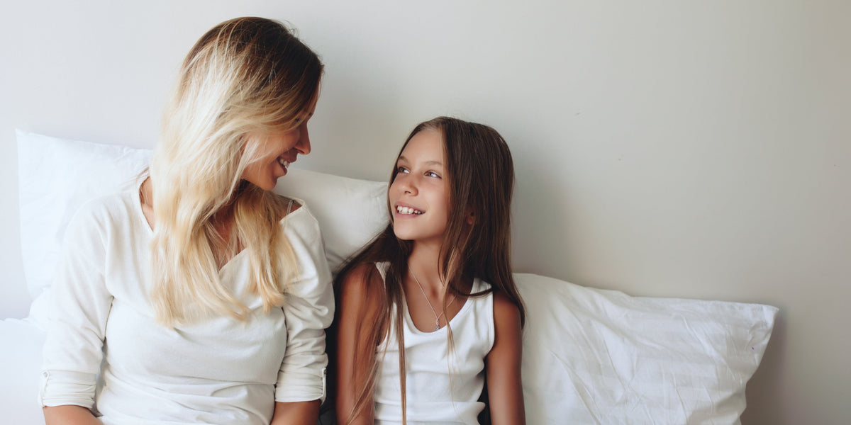 Mother and teen daughter talking at bedtime