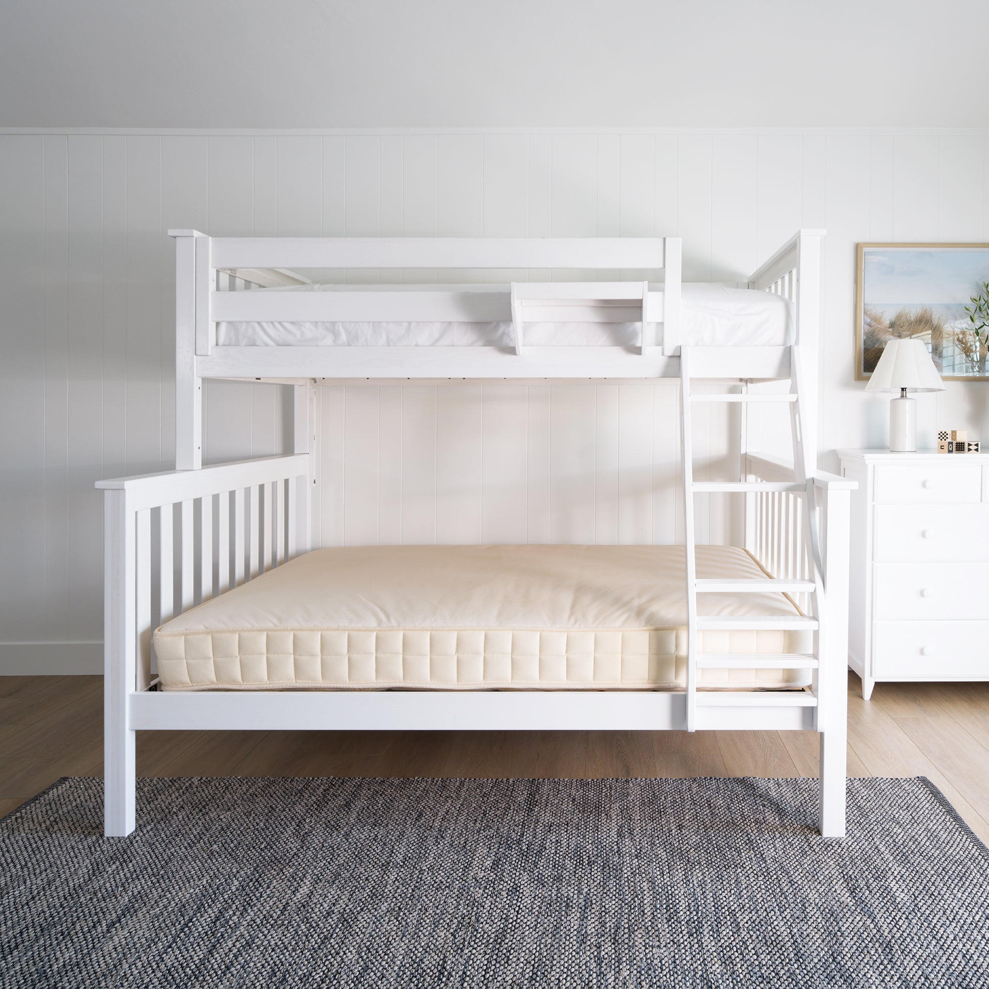 White bunk bed in a room with a gray rug and a dresser. #color_washed white #size_Twin/Full Bunk