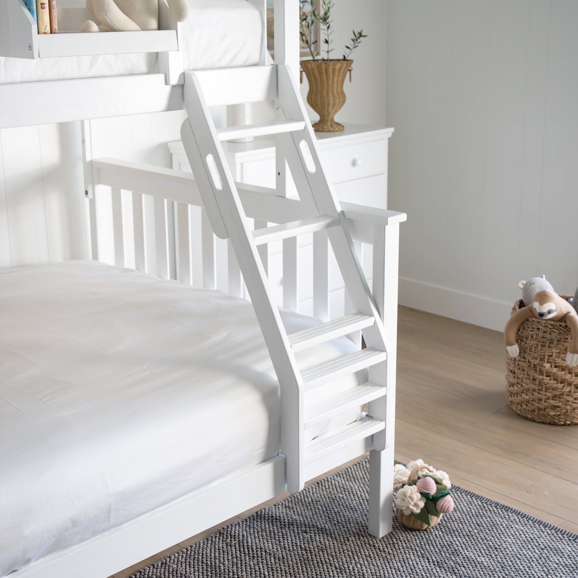 White bunk bed with a ladder in a room setting. #color_washed white #size_Twin/Full Bunk