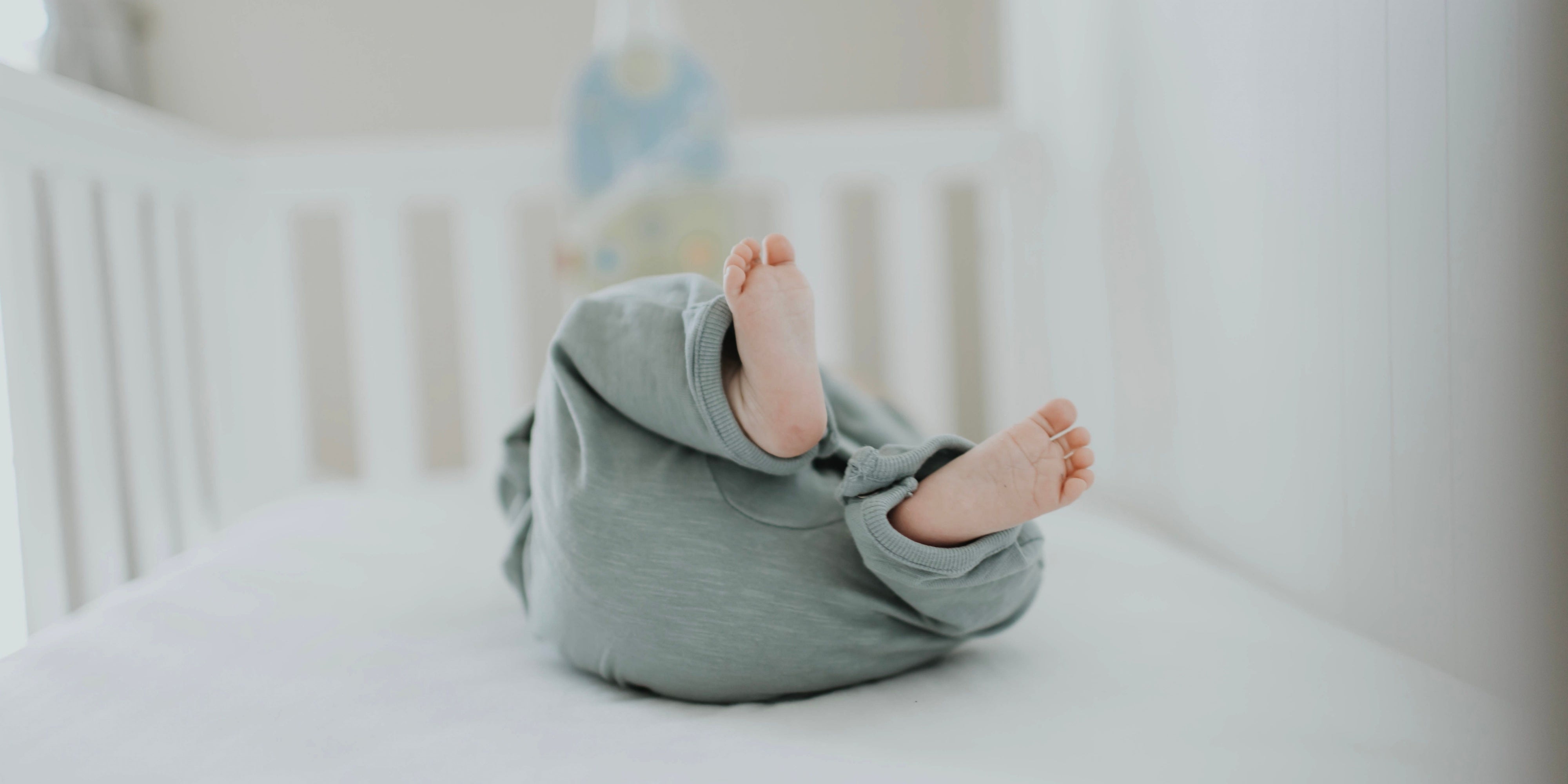 Tiny feet as Baby lies on a crib mattress