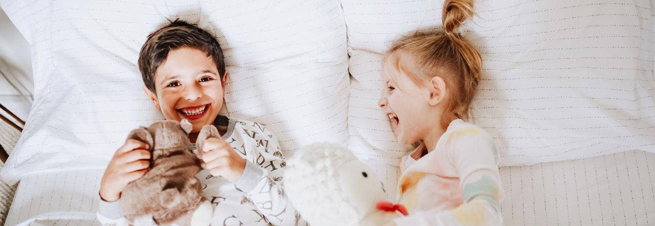 Two kids on a bed laughing