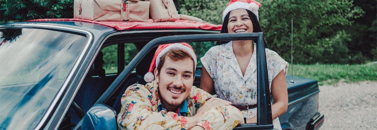 Friends wearing Santa hats and loading gifts into their car