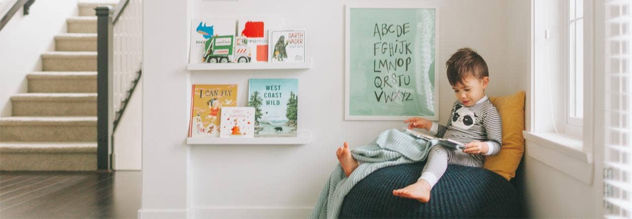 Young boy in pajamas, reading a picture book 