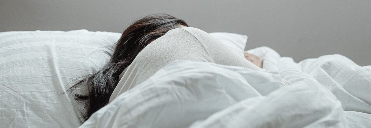 Woman oversleeping in a bright bedroom full of sunlight