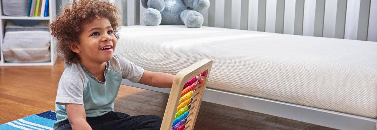 toddler playing next to big kid bed