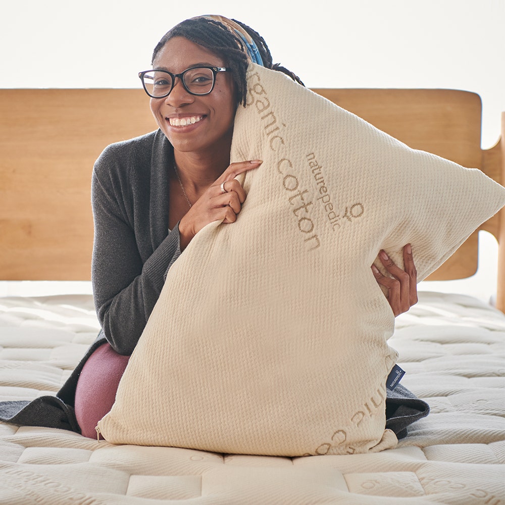 Woman laying in bed with body pillow