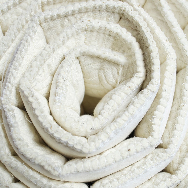 Side view of mattress quilt rolled up in spiral