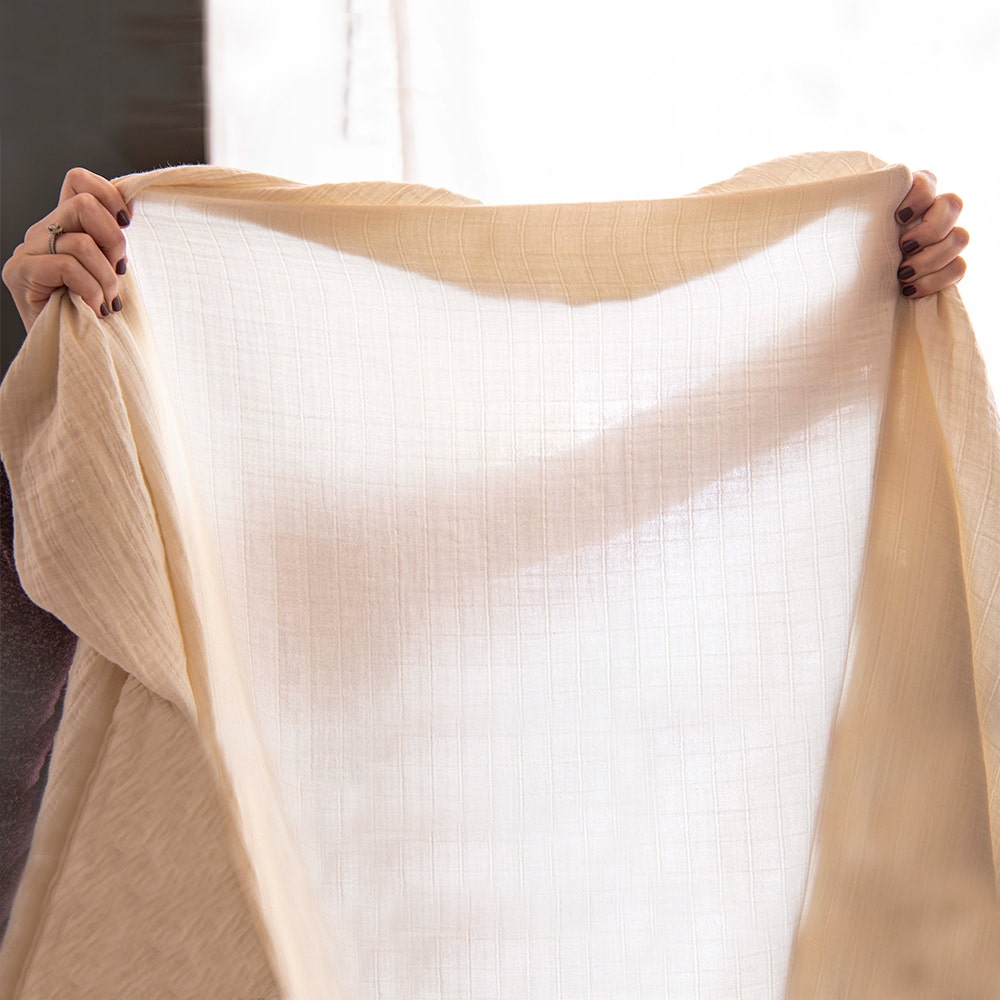 Crib sheet held up to show breathability