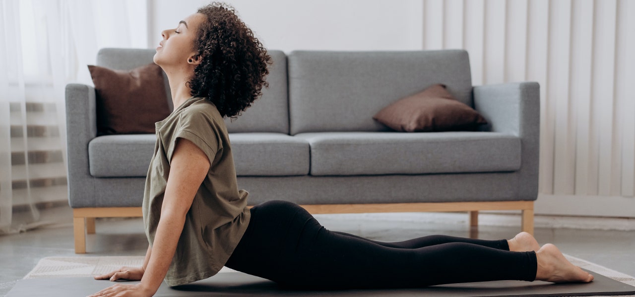 Woman practicing yoga at home in her living room