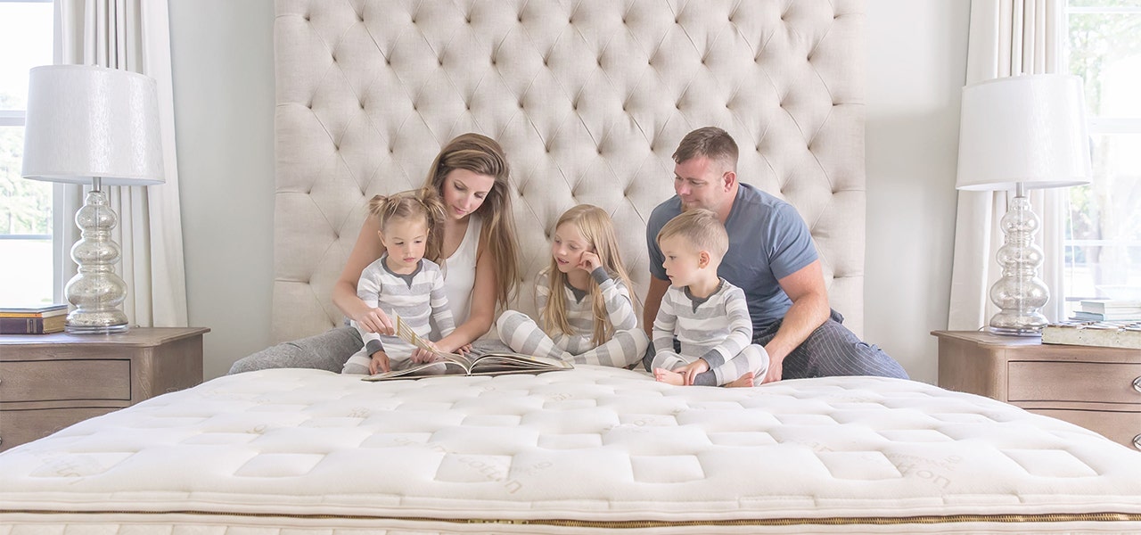 Family of five reading a book together on a Naturepedic organic mattress