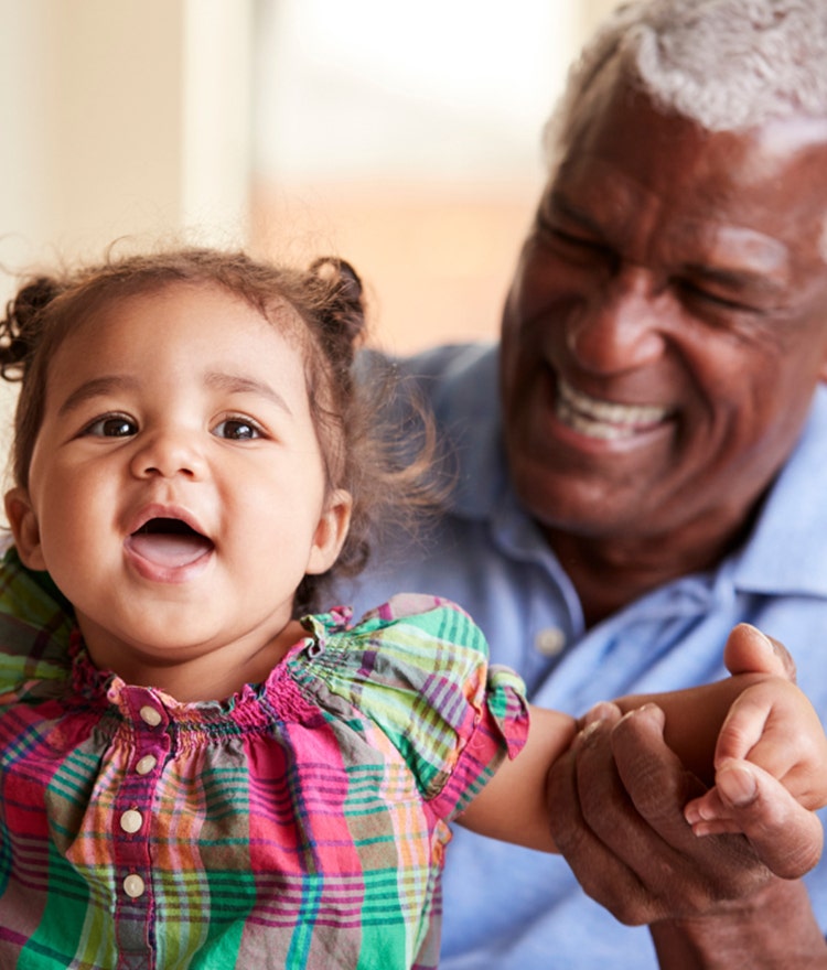 Grandfather playing with a smiling toddler