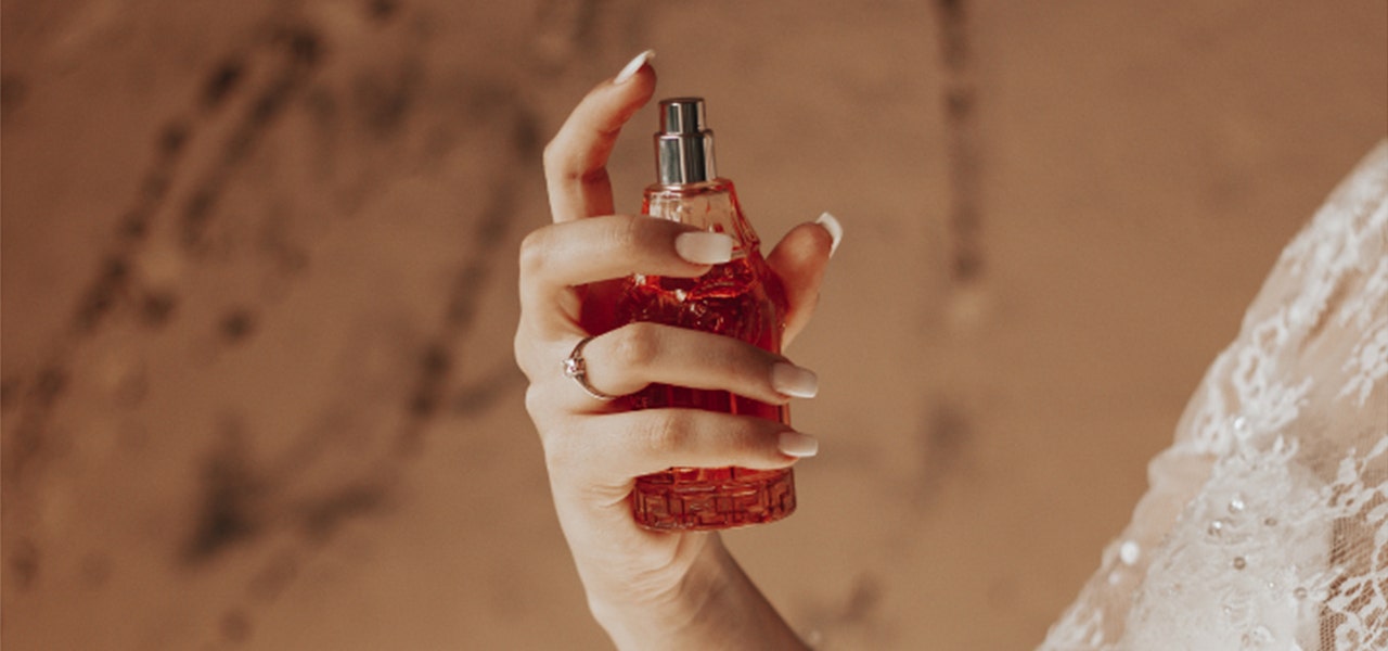 Woman spraying a non-toxic perfume made without synthetic frangrances