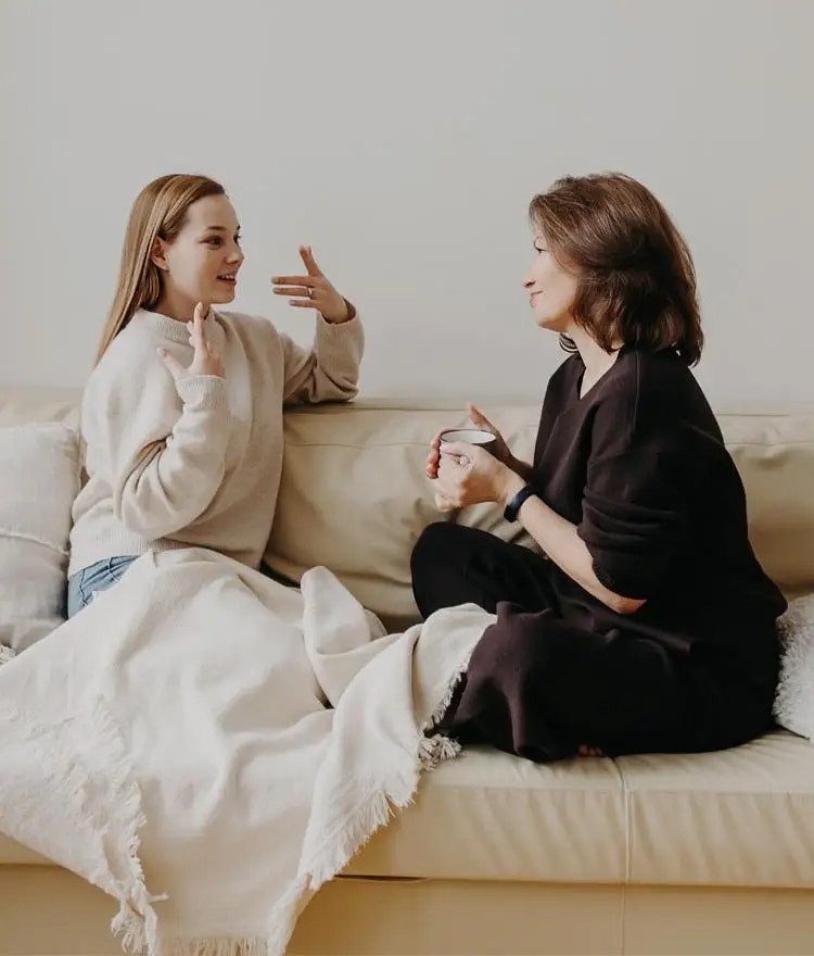 Parent and teenage child talking in bed