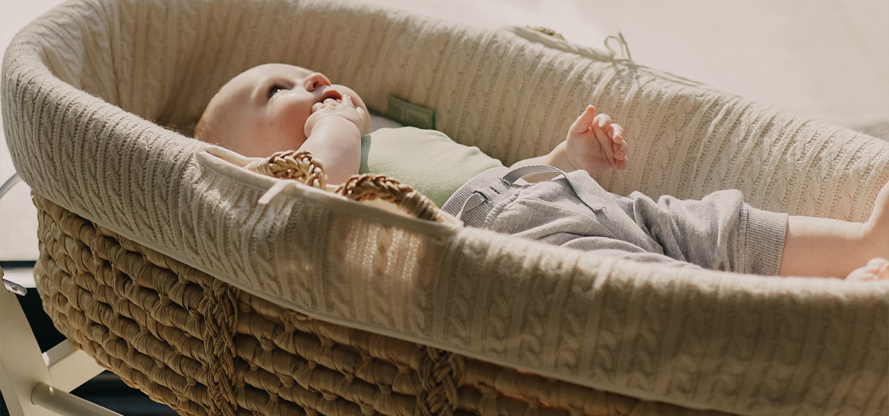 Small infant lying on their back in a bassinet