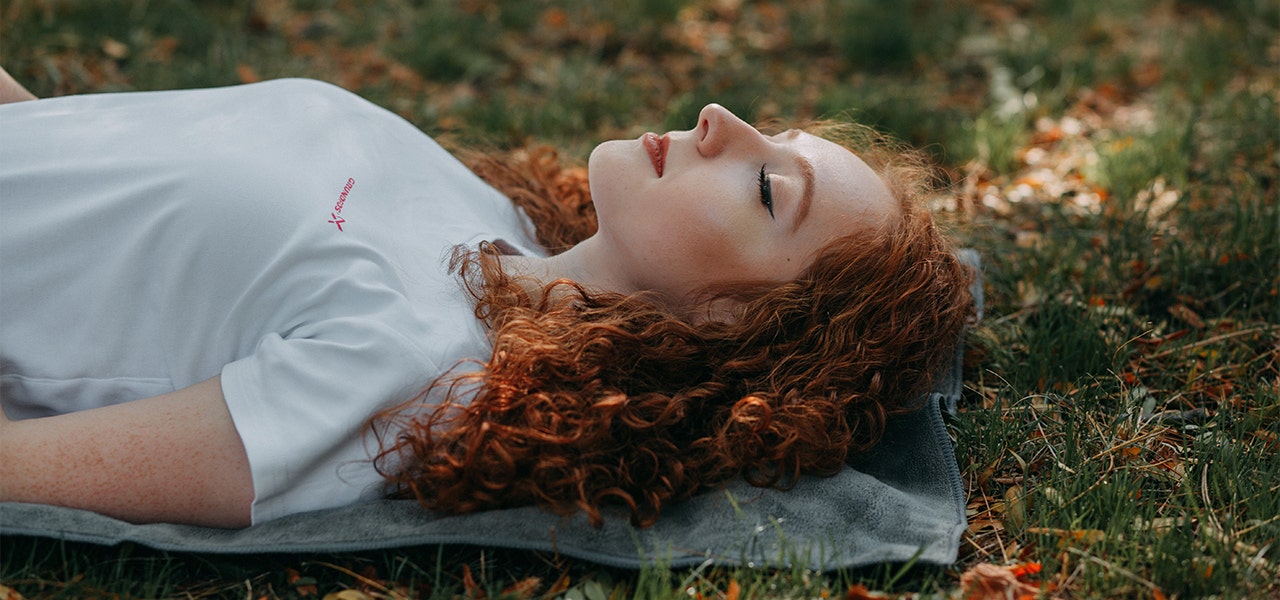 Woman napping on a blanket outside in the sun