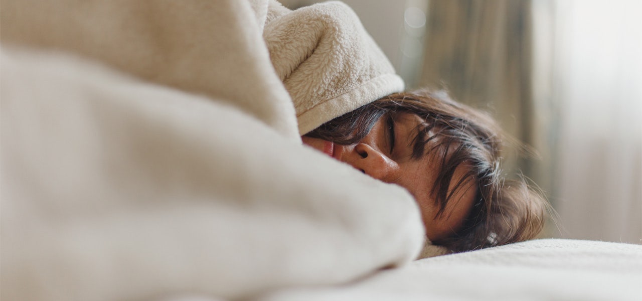 Woman wrapped in a blanket and comfortably sleeping