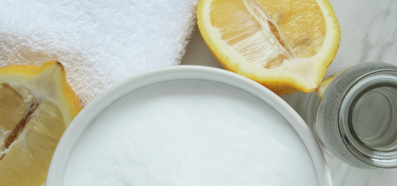 Overhead view of fresh sliced lemon, baking soda and vinegar for DIY cleaning solution