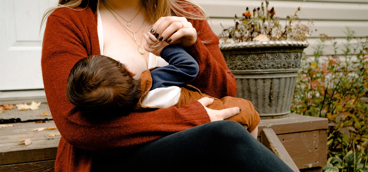 Mother breastfeeding her baby outside on her porch steps