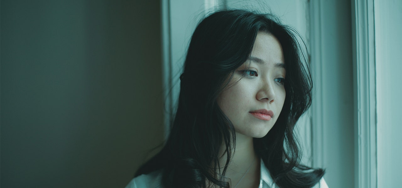 Woman looking out the window and feeling stressed