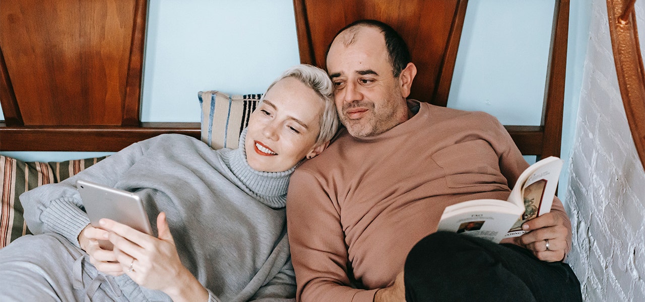 Relaxed couple reading in bed together