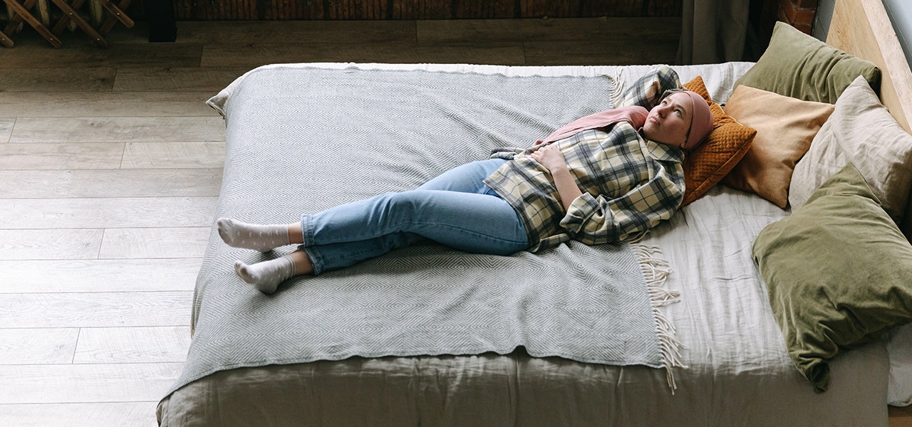 Young woman lying awake in bed, looking up at the ceiling