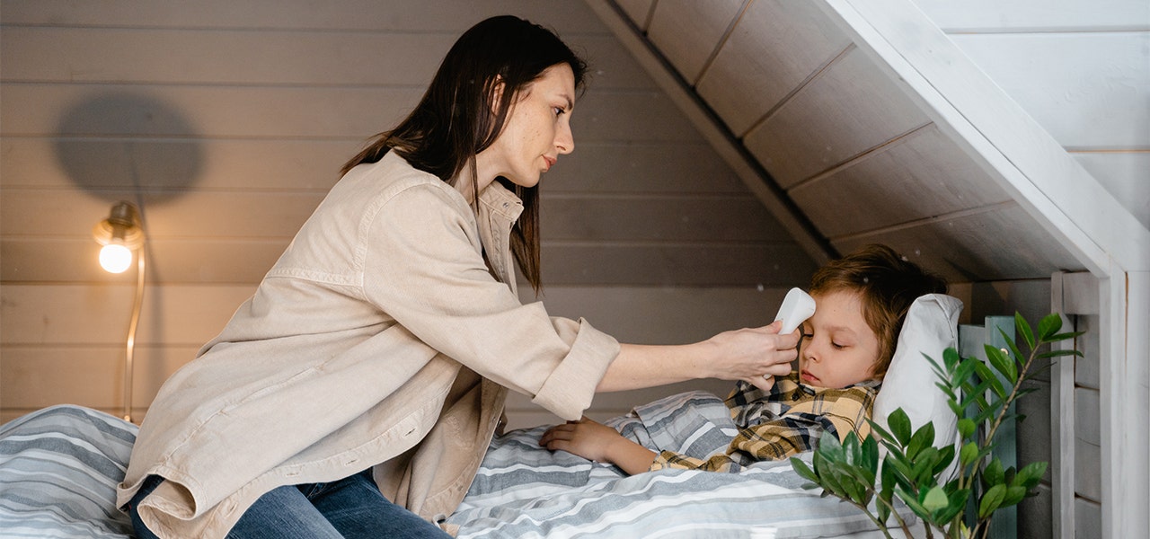 Mother taking child's temperature at home