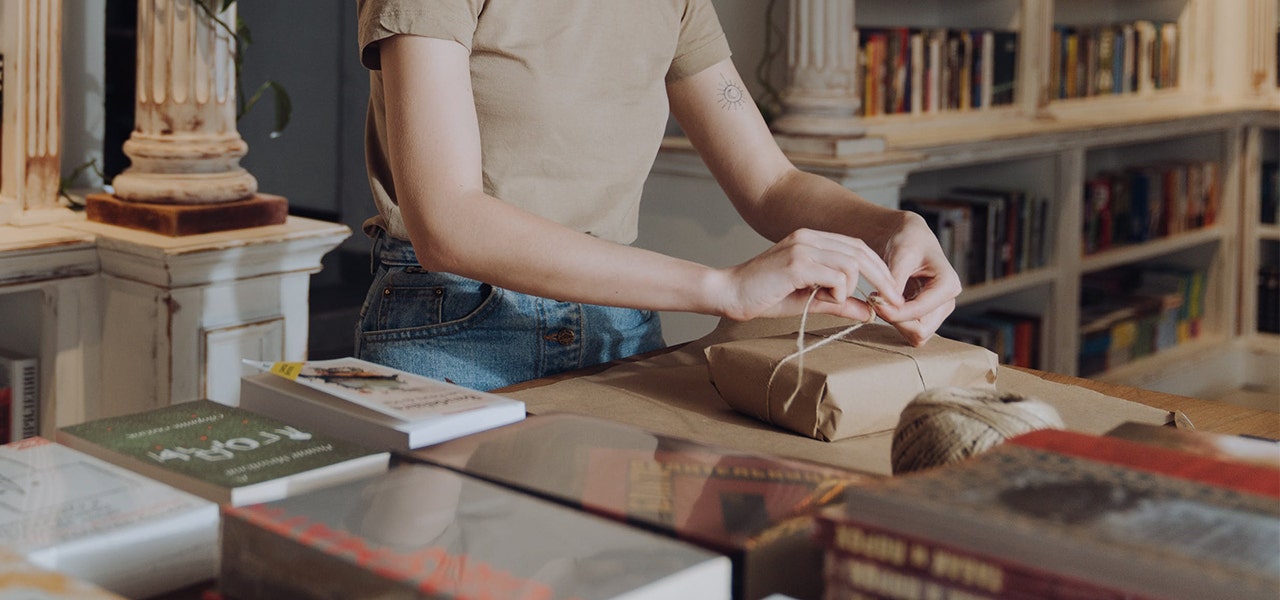 Woman repurposing kraft paper packaging as gift wrap