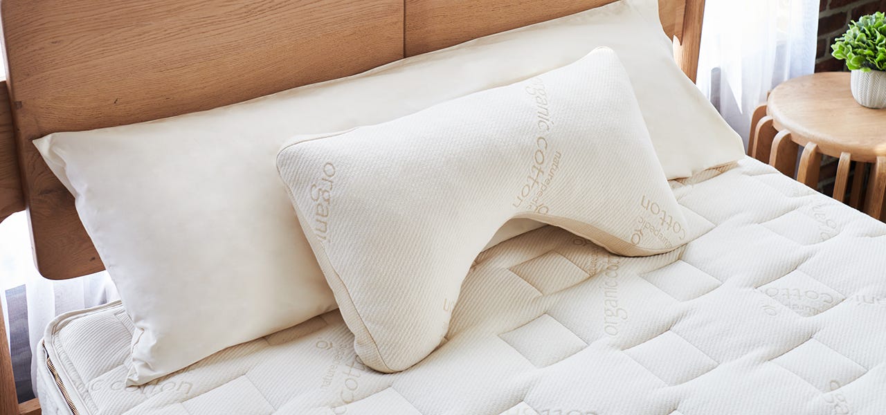 Naturepedic organic side sleeper pillow propped up on a bed