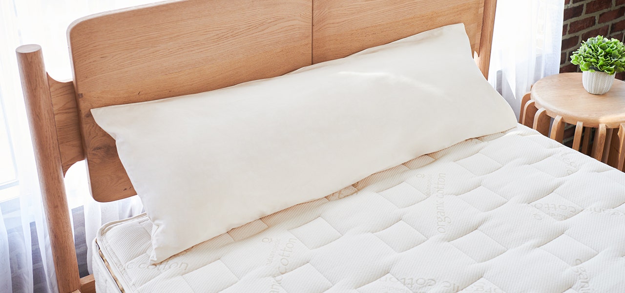 New Narurepedic Organic Cotton/PLA Body pillow displayed on a bed with an organic mattress