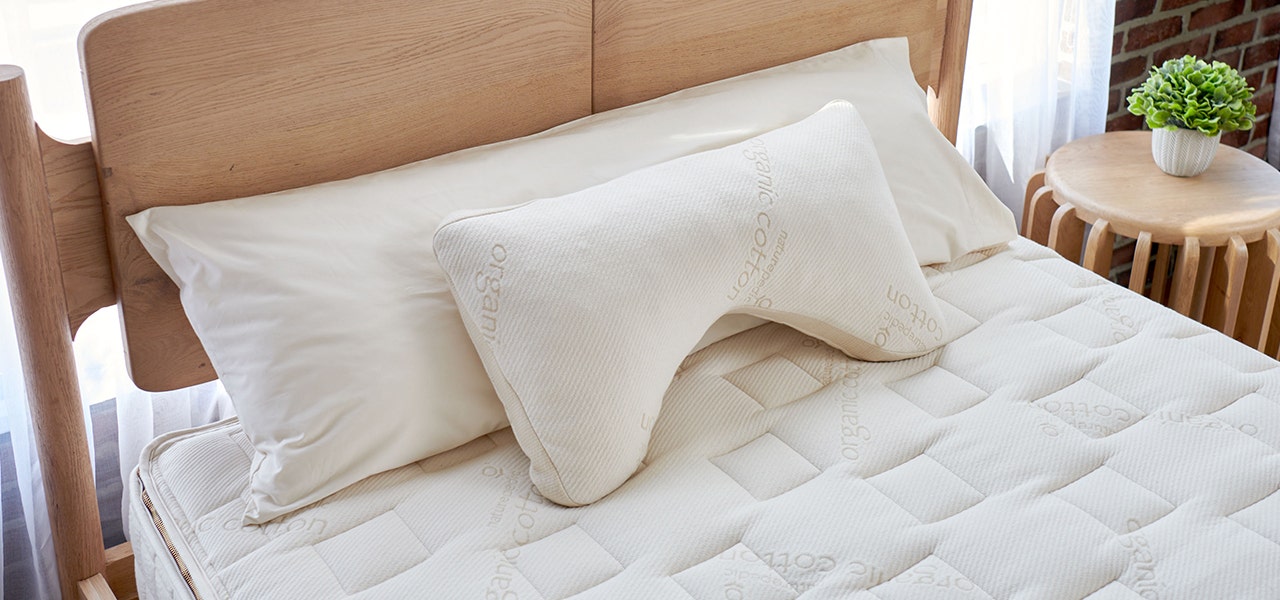 Naturepedic side sleeper and body pillows on a clean organic mattress