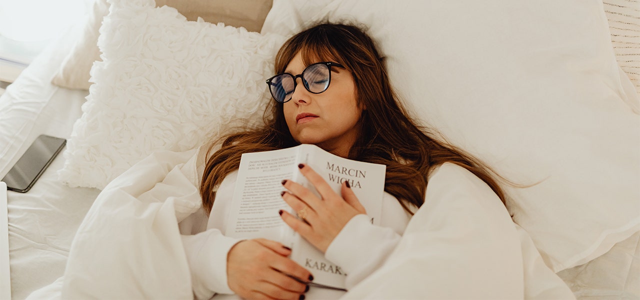 Woman dozing in bed with a book on her chest