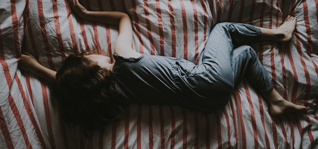 Small child sleeping soundly on a striped duvet