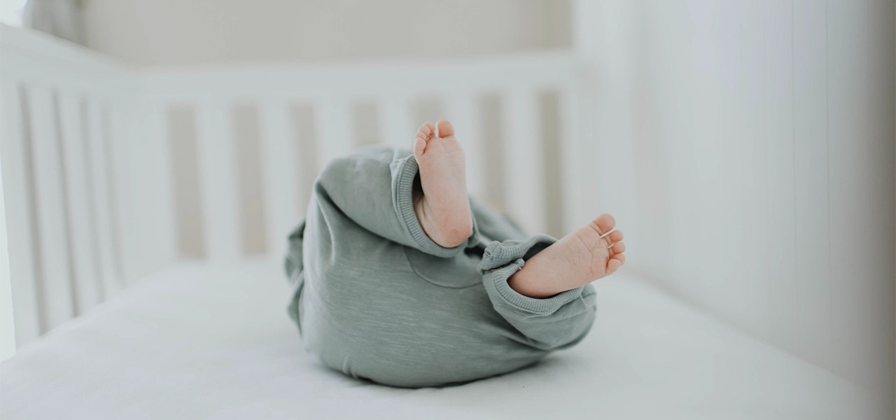 Newborn baby lying on their organic mattress