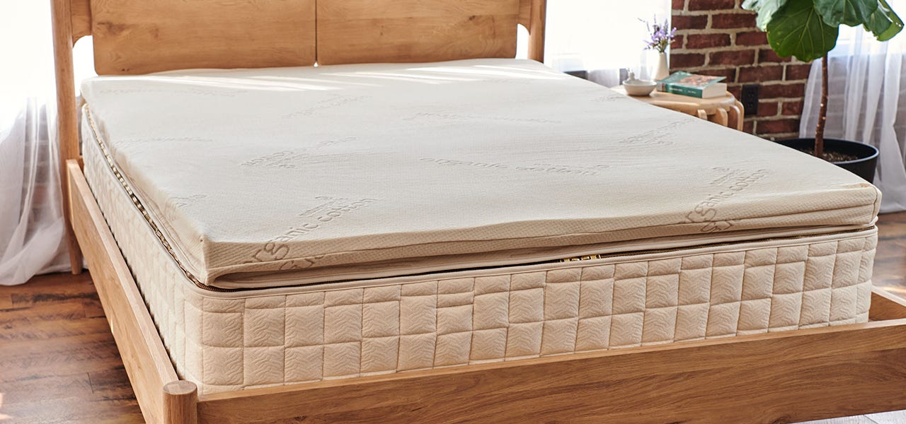 naturepedic mattress with a naturepedic latex mattress topper set up in a bedroom