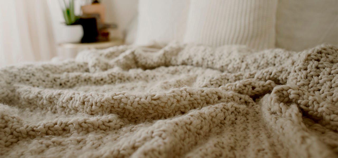 knit brown blanket on bed