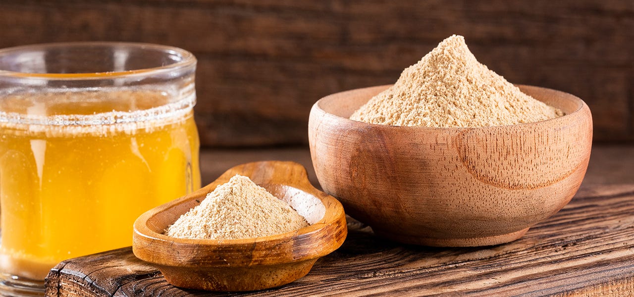 maca root powder in wooden bowls and jar of honey