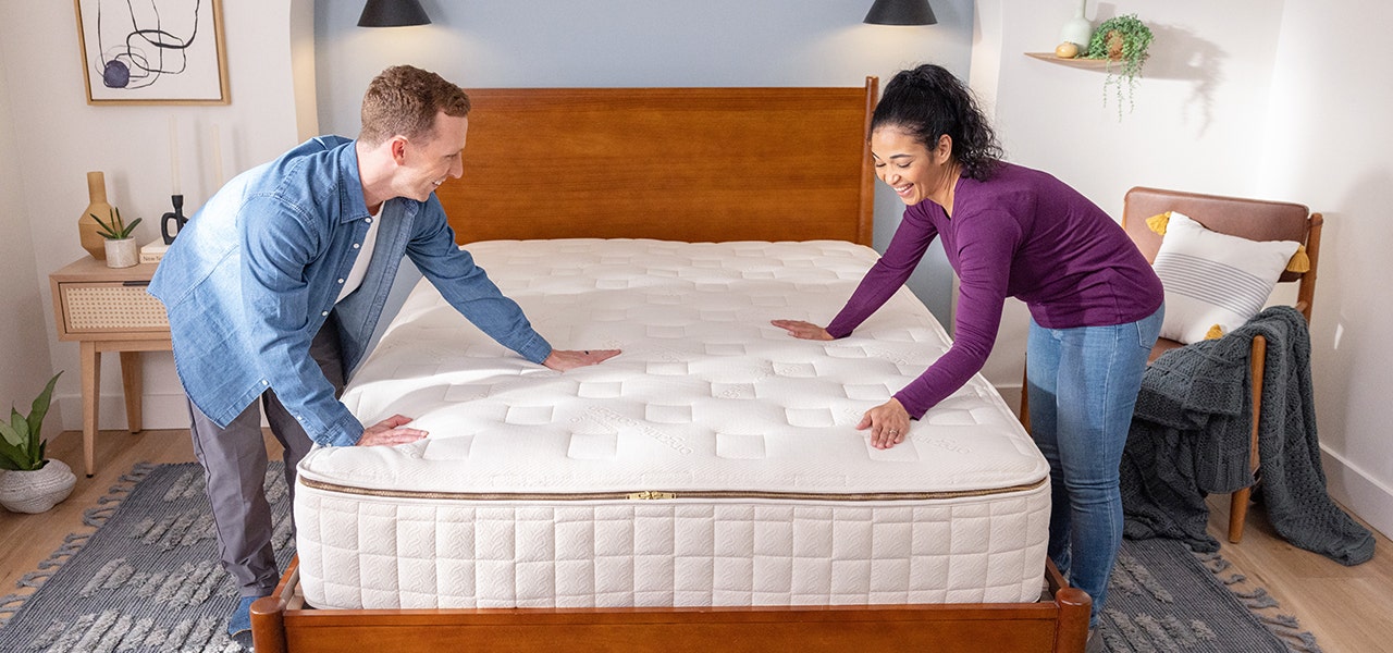 couple smoothing out their EOS organic mattress top
