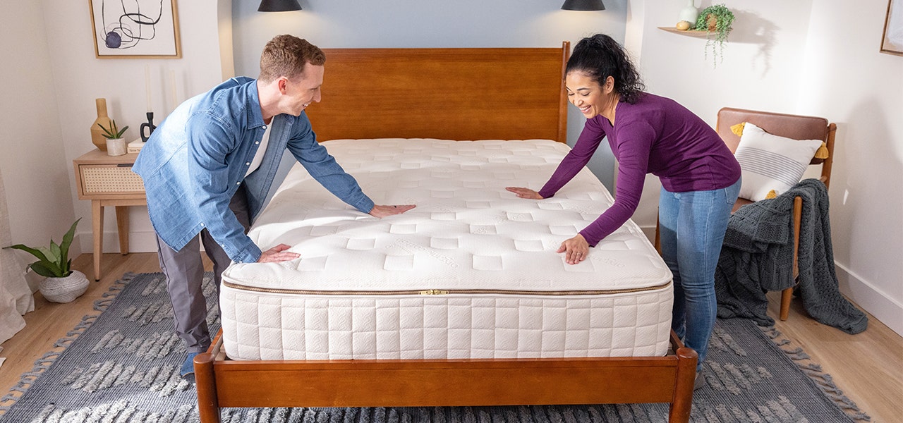 couple smoothing out quilt of their EOS organic custom mattress