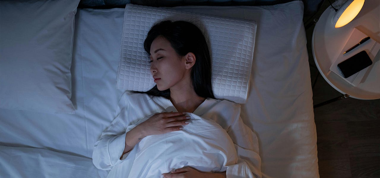 person sleeping on back in bed