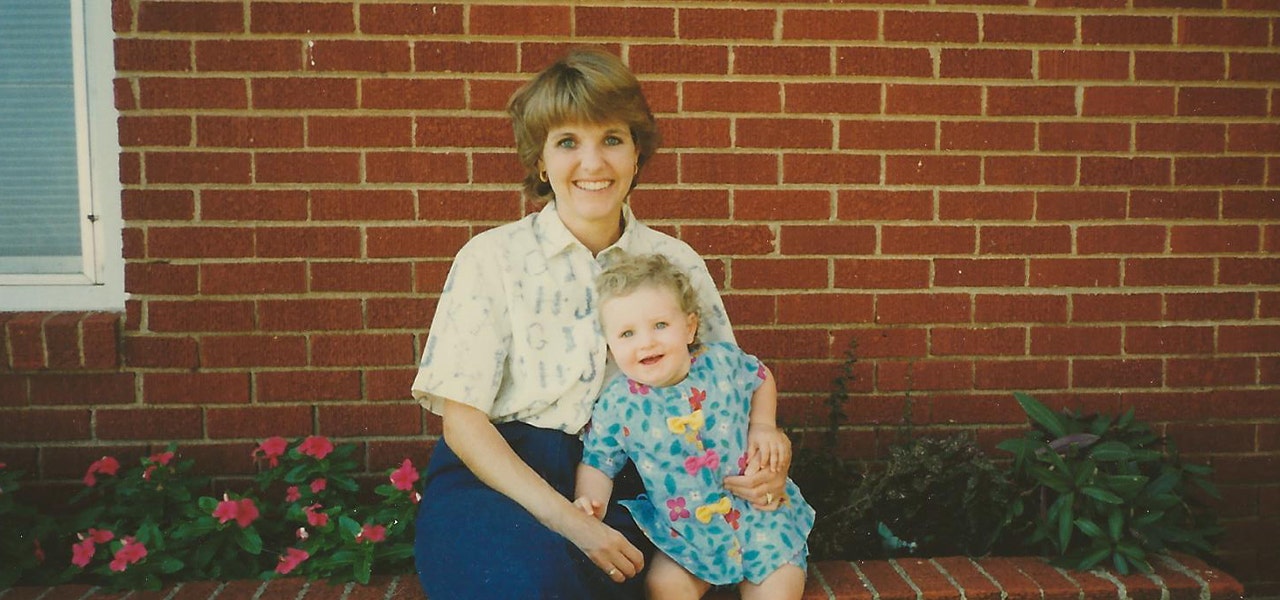 mother and child in front of a brick house