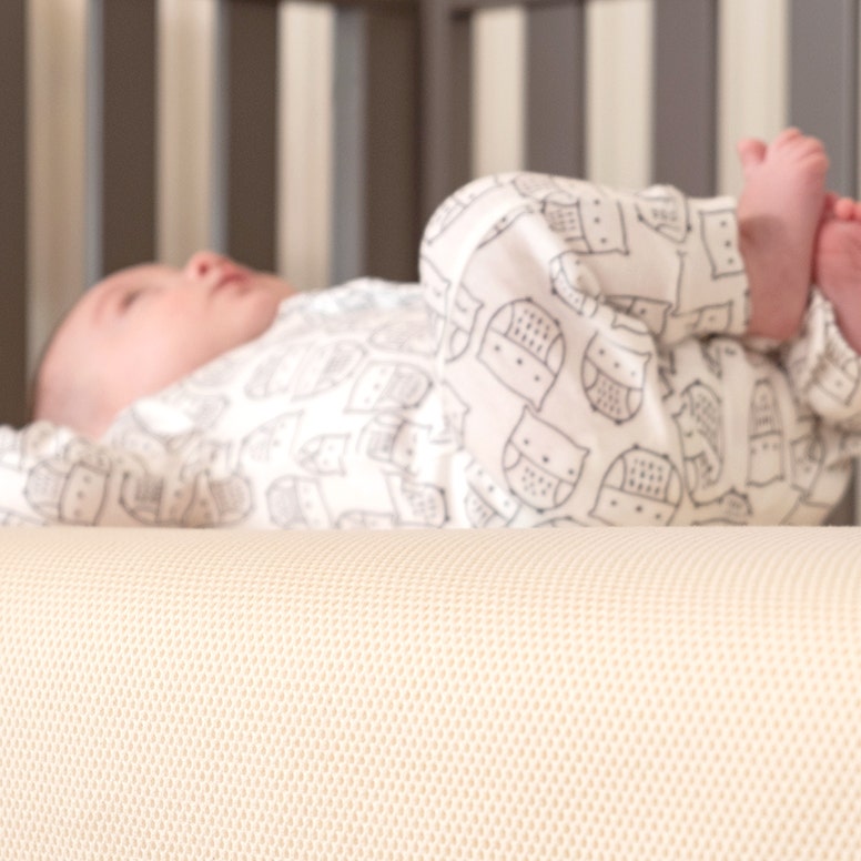 Baby laying on back on breathable crib mattress