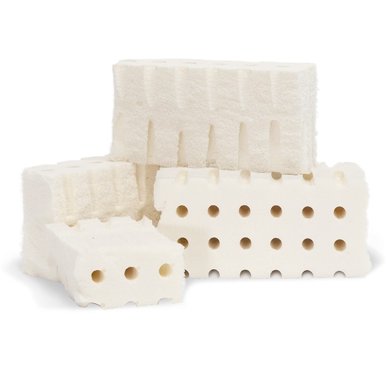 Stacked chunks of organic latex foam on white background