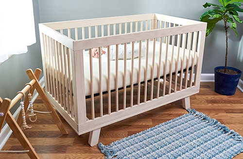 Crib set up in a nursery with a Naturepedic breathabke mattress